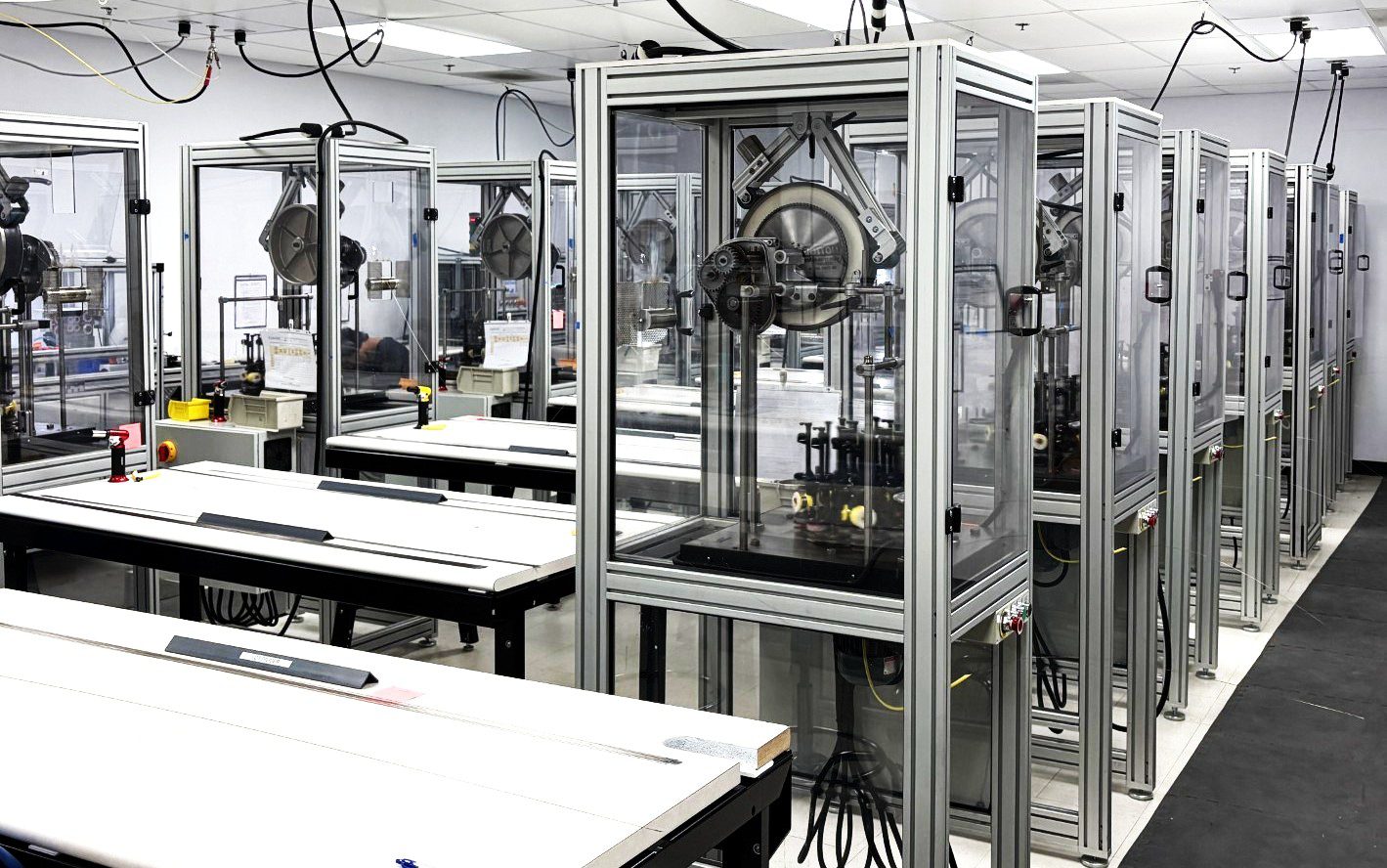 Row of enclosed robotic manufacturing stations